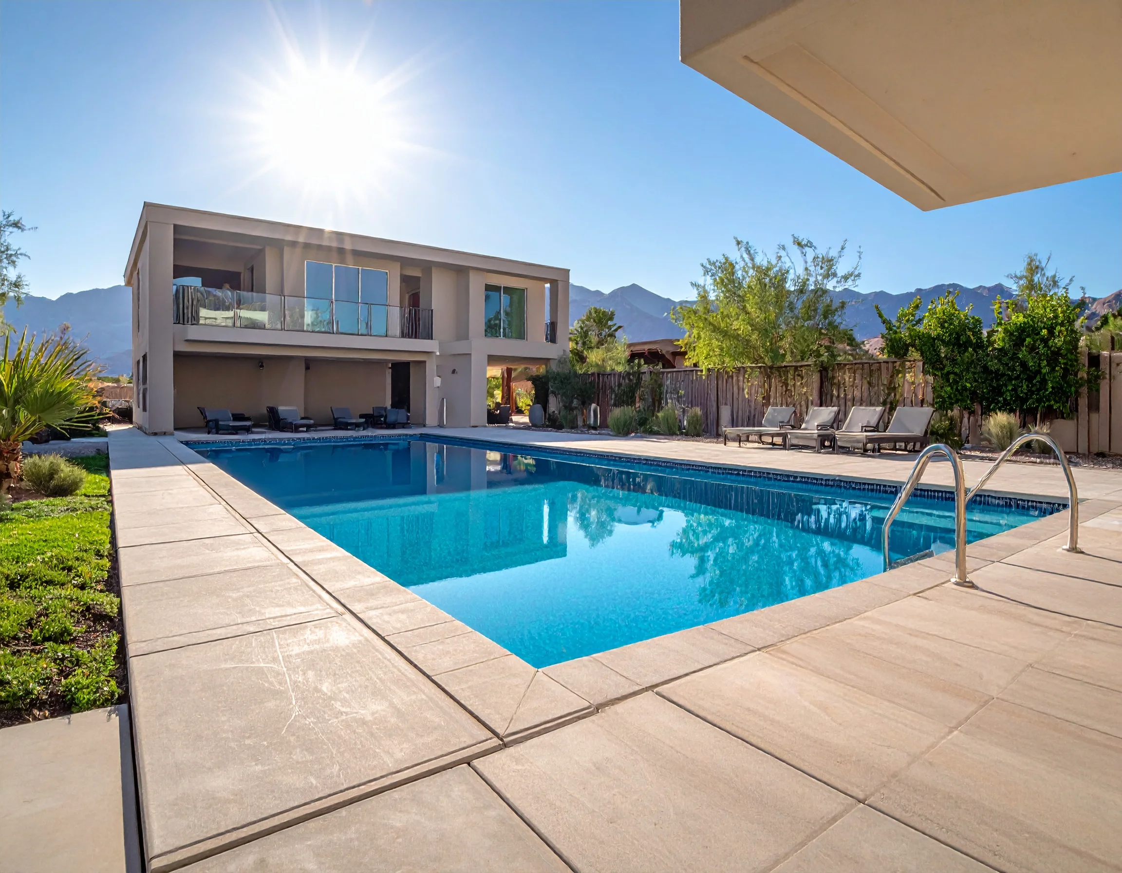Modern pool in morning light with mountain views.